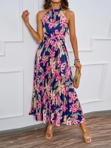 Detail of elegant halter neck summer dress featuring blue floral print and pleated skirt design