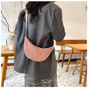 Detailed close-up of pink corduroy crescent bag showing texture and adjustable strap