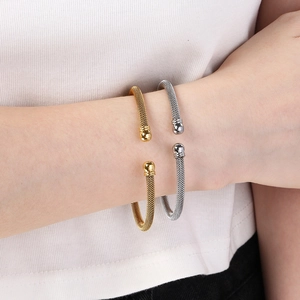 Detail of 18K gold and silver mesh woven cable bangles with spherical metal ends
