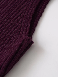 Gros plan sur la texture du tricot côtelé violet foncé montrant des motifs élastiques
