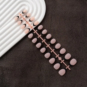 Detailed view of 24pcs nude press-on nails with black French tips on a wave display