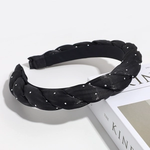 Detail of a padded black braided headband with shimmering silver rhinestones