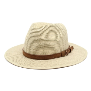 Détail du chapeau de paille beige avec ruban en daim marron et boucle dorée élégante