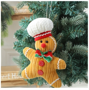 Close-up of a gingerbread man ornament with a chef hat hanging on a Christmas tree