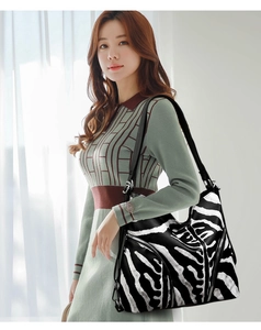Detail showing the black and white zebra pattern on a casual leather shoulder tote bag