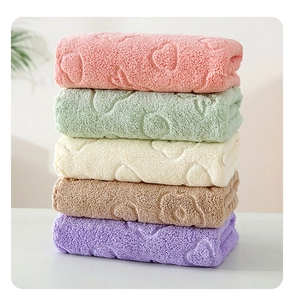 Macro detail of soft coral fleece towels with embossed bear and heart textures