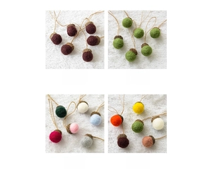 Detail view of four color styles of wool felt acorn ornaments with natural caps