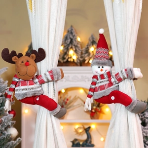Detail of plush reindeer and snowman Christmas curtain tiebacks on white curtains