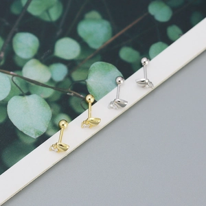 Macro detail of gold and silver leaf screw-back earrings with sparkling cubic zirconia