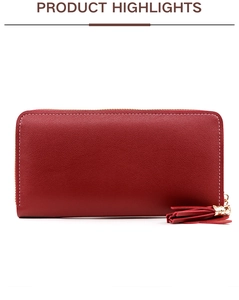 Detail of red pebbled leather wallet with white stitching and tassel zip charm
