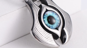 Macro shot of silver stainless steel Evil Eye pendant with gradient blue glass inlay