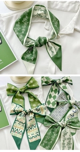 Floral green silk scarf tied on white shirt collar showing elegant styling details