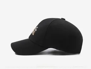 Detailed side view of black baseball cap featuring gold embroidered outdoor lettering