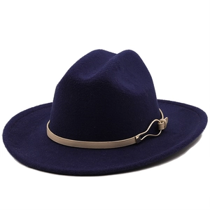 Detail of navy wool fedora hat featuring a light brown leather band and gold metal buckle