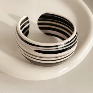 Minimalist wide open cuff bracelet featuring modern black and white striped acetate patterns