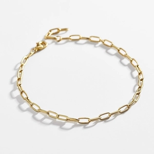 Detail of a polished golden paperclip chain bracelet with a secure lobster clasp