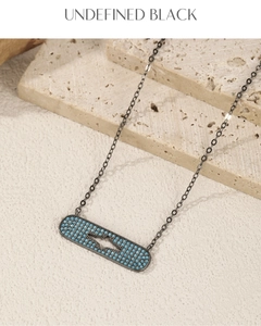 Macro detail of lightning bolt pendant with blue beads on textured stone
