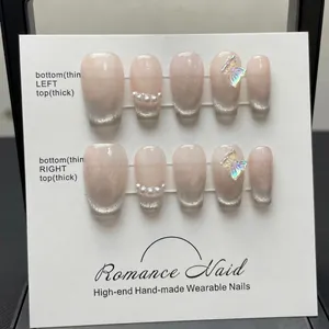 Handmade cat eye press-on nails with silver butterfly and pearl accents on display