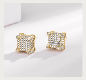 Macro detail of gold-plated cube stud earrings featuring micro-paved cubic zirconia stones