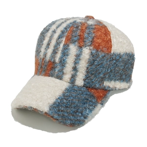 Detail of multi-color plaid sherpa baseball cap showing warm teddy fleece texture
