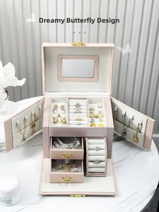 Detailed interior of multi-layer pink leather jewelry box with mirror and soft velvet lining