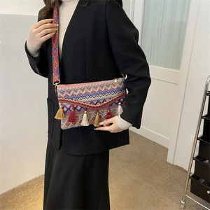 Close-up of Bohemian crossbody bag with colorful tassels and ethnic pattern strap