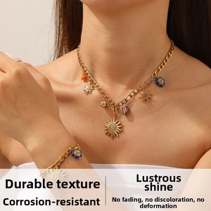 Close-up of gold-plated sun pendant necklace and bracelet set with colorful beads