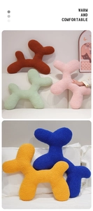 Detailed view of colorful dog-shaped plush pillows in soft sherpa fleece fabric