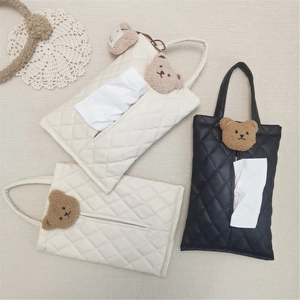 Close-up of quilted PU leather car tissue holder with cute plush bear and handle