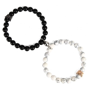 Detailed shot of magnetic couple bracelets with black matte beads and crown charms