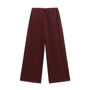 Vista dettagliata dei pantaloni larghi in maglia rosso scuro con trama verticale e tessuto