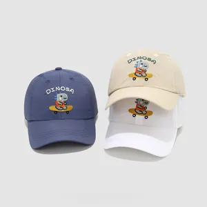 Detail of embroidered skateboarding dinosaur pattern on cotton kids' baseball caps