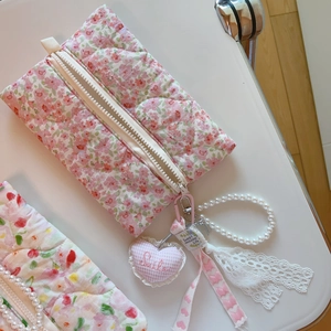 Détail du sac matelassé à fleurs roses avec dentelle, chaîne en perles et pendentif cœur