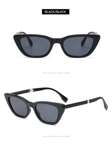 Detail view of foldable black cat-eye sunglasses with gold metal hinges and dark grey lenses