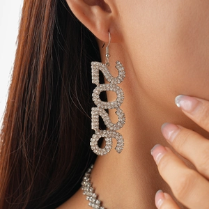 Close-up of 2026 number drop earrings with sparkling rhinestones on a female model