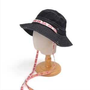Detail eines schwarzen Fischerhuts aus gewaschenem Denim mit Schmetterlingsband
