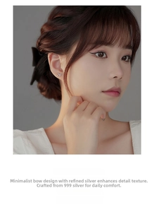 Detailed view of S999 sterling silver bow earrings worn by a model in natural light
