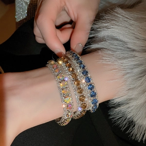 Detailed view of three luxury bracelets featuring blue, amber, and multi-color gemstones