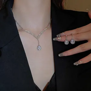 Elegant V-shaped waterdrop jewelry set with sparkling rhinestones worn by a model