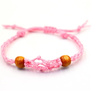 Detalle de pulsera boho tejida a mano en rosa con diseño de malla y cuentas de madera