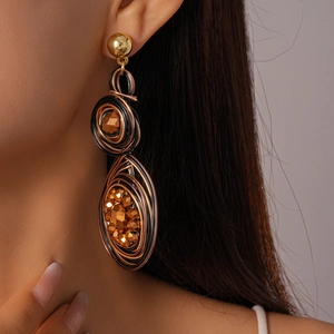 Close-up of vintage geometric earrings with woven metal wire and faceted crystals
