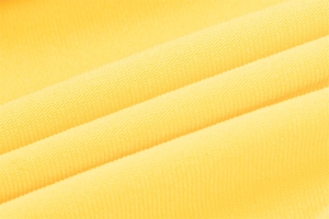 Macro shot of yellow fabric texture and high-quality material on a summer slip dress