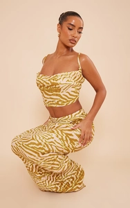 Detailed view of yellow zebra print pleated fabric on a slim-fit two-piece set