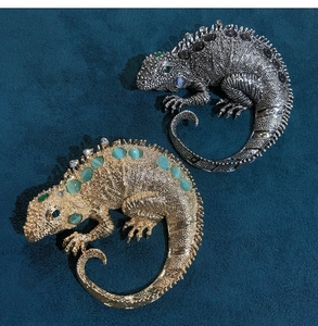 Detailed view of lizard brooches with opal stones and sparkling rhinestones on velvet