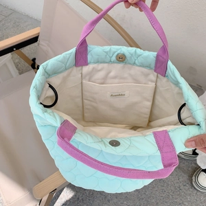 Détails du sac matelassé vert menthe avec fermeture magnétique et anses violettes