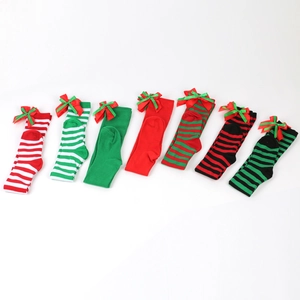 Detail of Christmas over-knee socks with festive stripes and colorful ribbon bows