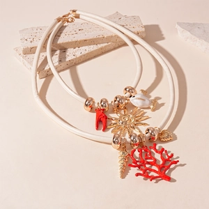 Detail of layered leather cord necklace with sea-themed charms like coral and sun