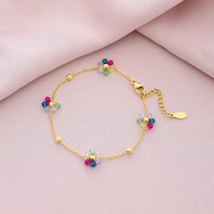 Gold stainless steel bracelet with five multicolored crystal flowers on pink fabric