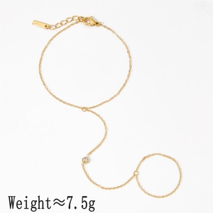 Elegant gold stainless steel slave bracelet with a round white zircon stone on white background