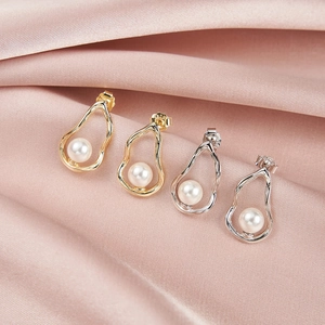 Detail showing S925 hallmark on shell pearl earrings with gold and silver finishes